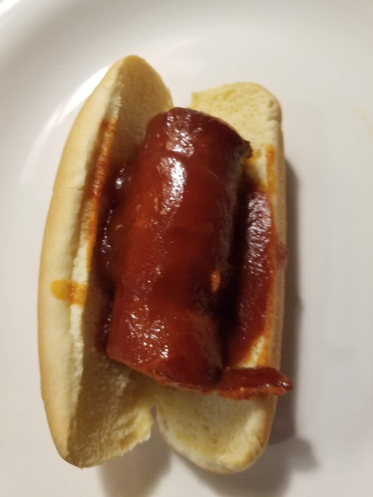 Finished Sweet and Spicy Sausage Po-Boy in a soft bun with glossy sausage